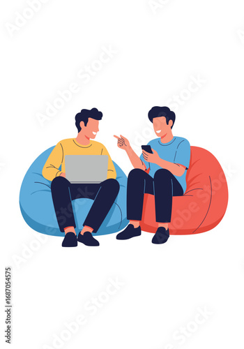 Two happy friends relaxing on beanbag chairs discussing something on a laptop and phone