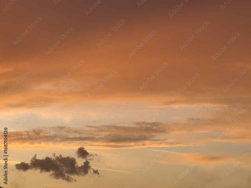 Fototapeta premium Vibrant sunset displaying a beautiful blend of orange, pink, and purple hues over a tranquil landscape at dusk