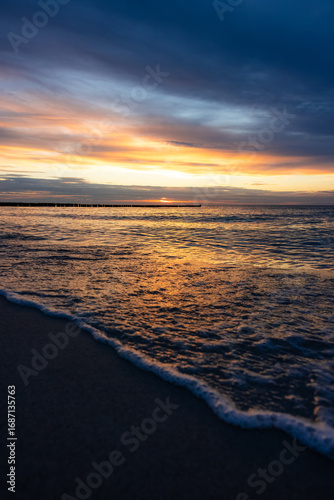 Sonnenuntergang am Strand mit Wellen