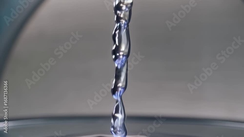 Mesmerizing Stream of Shiny Liquid Metal Mercury Pouring in Fluid Motion on Reflective Surface Creating Smooth, Glossy Patterns and Dynamic Sheen