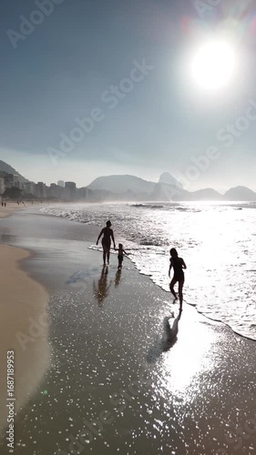 Mother and Child Playing with a Dog on Copacabana Beach at Sunrise, Rio de Janeiro