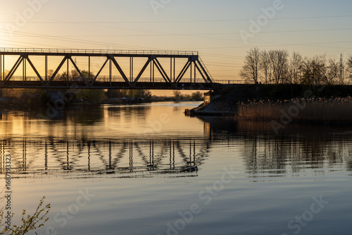 Spring evening on Ķīšezers lake, Latvia, by the old railway bridge in Riga, Jugla, with reeds reflecting in the water