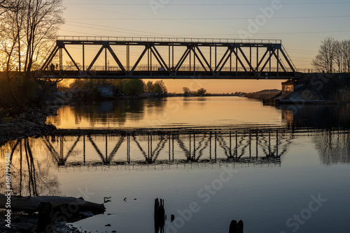 Old railway bridge converted into a pedestrian walking path at spring sunset in Jugla