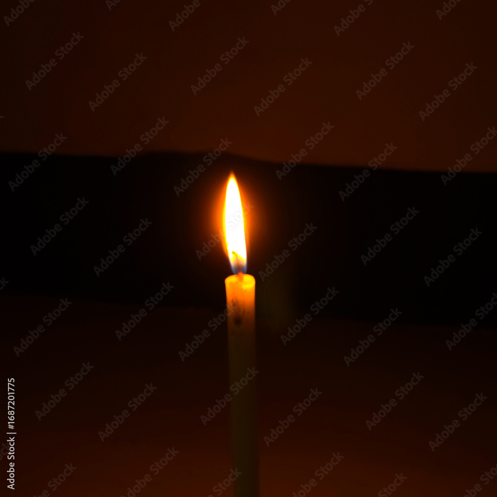 Fototapeta premium Glowing Candle Flame In Darkness