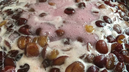  Close-up of plum jam being cooked. Hot steam from boiling plum jam