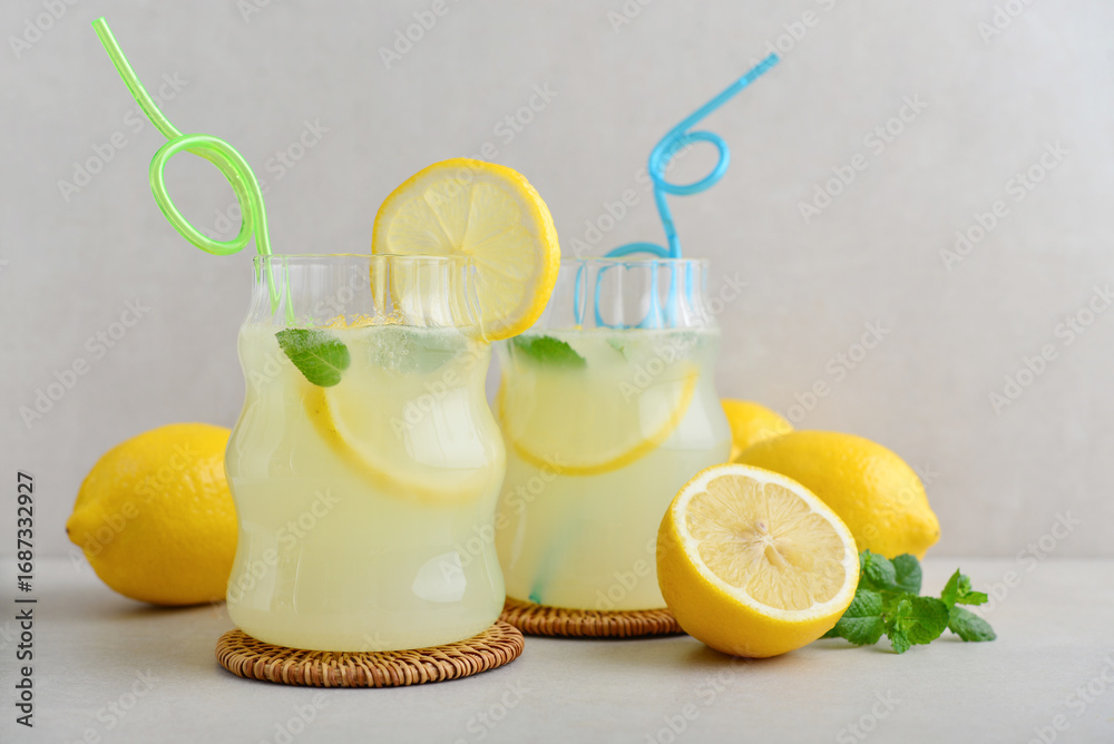 Fototapeta premium Two glasses of homemade lemonade with drinking straws