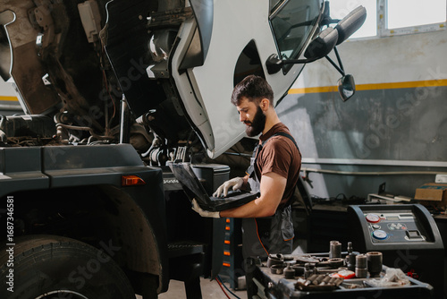 Skilled auto mechanic repairing large truck engine