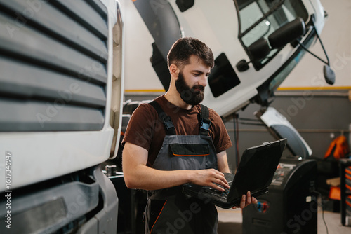 Fotografi Auto mechanic using laptop to diagnose truck issues