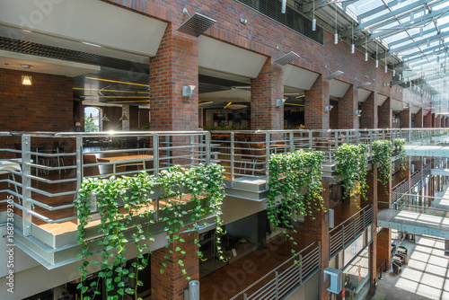 Tableau sur toile Multi-level atrium featuring brickwork, plants, and natural light, creating an open and inviting indoor environment