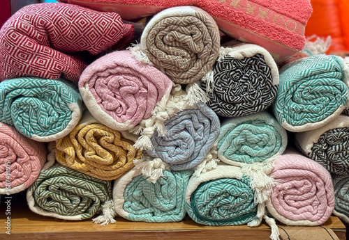 Rolled patterned textiles stacked in outdoor retail market. Home decor, lifestyle, and consumer shopping concept in textile commerce.