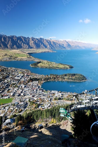 This stunning aerial view captures Queenstown, South Island, New Zealand, nestled by Lake Wakatipu and surrounded by The Remarkables mountain range under a clear sky. Taken on May 18, 2025.