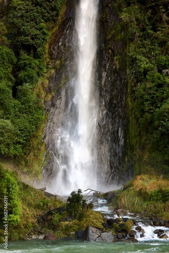 Thunder Creek Falls, South Island, New Zealand, captured on May 16, 2025, features cascading water, lush greenery, and rocky terrain in a misty natural landscape.