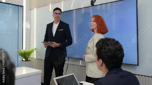 Business team in modern meeting room discussing data analytics on digital screen with charts and graphs, representing teamwork, strategy, innovation, and corporate success.