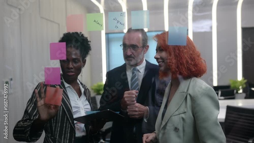 Diverse business team brainstorming with sticky notes in modern office, discussing strategy, innovation, and teamwork collaboration for project planning and creative business solutions.