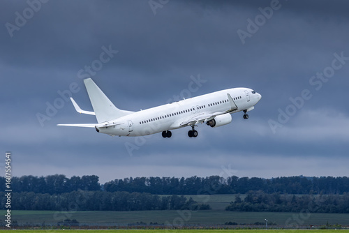Modern white passenger plane takes off runway in cloudy weather