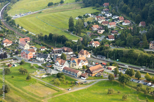 Fototapeta Naklejka Na Ścianę i Meble -  Aerial view of a small village in Saxon Switzerland, Germany. Residential houses, green fields, and roads create a harmonious rural European landscape.