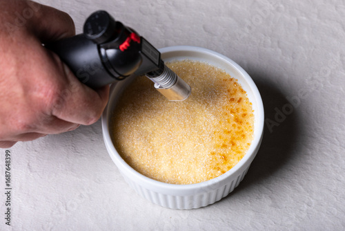 Obraz na plátně Caramelizing Crème Brûlée with Kitchen Torch