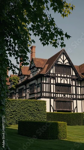 Wallpaper Mural Charming Tudor-style house with intricate woodwork, captured from a low-angle, ideal for a historical video backdrop with lush greenery. Torontodigital.ca