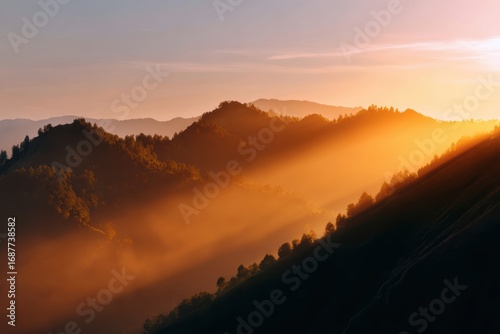 Fototapeta Naklejka Na Ścianę i Meble -  scenic sunset over misty mountains with warm golden light