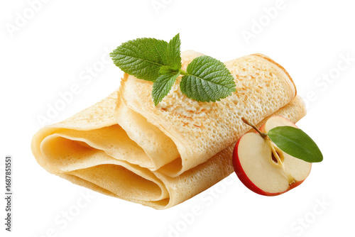 Stacked golden-tan crepes, slightly browned, with fresh mint leaves and a sliced red apple