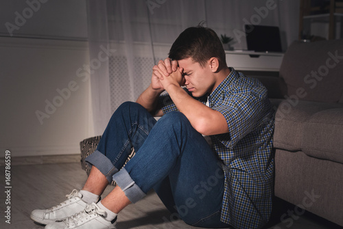 Obraz na plátně Teen depression and anxiety concept. Desperate boy in dark room