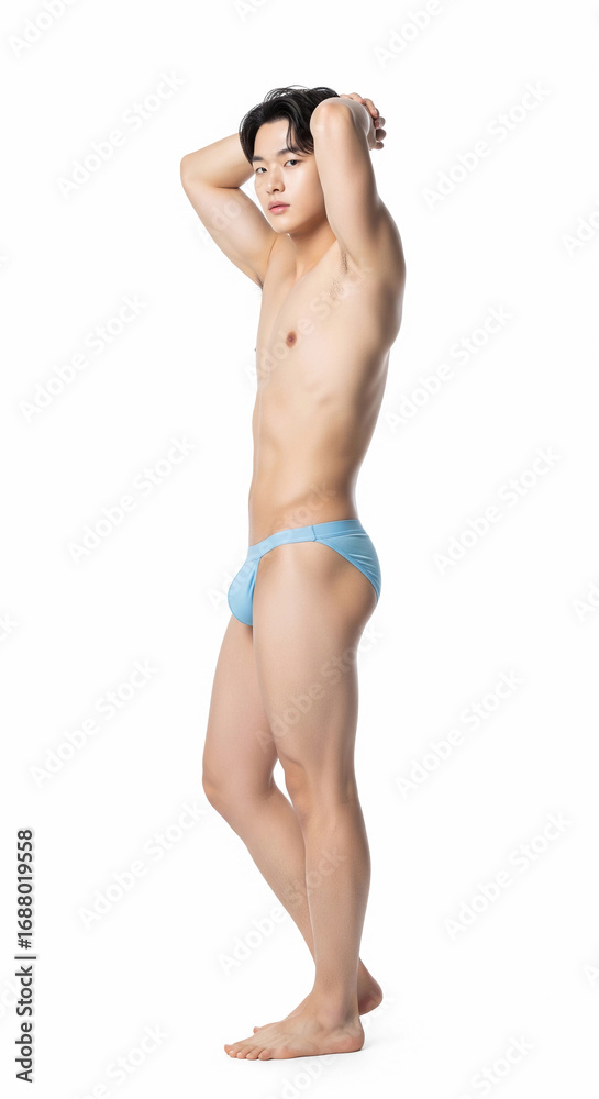 Obraz premium An alluring young Asian man poses confidently in colorful swimwear, showcasing a toned body. Captivating fashion and sensuality in a clean, minimalist studio setting.