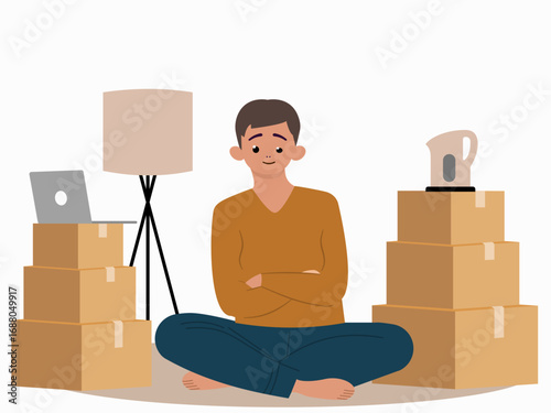 Young man sitting on the floor surrounded with boxes. Moving in or out concept