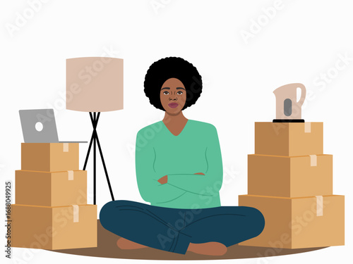 Young woman sitting on the floor surrounded with boxes. Moving house concept