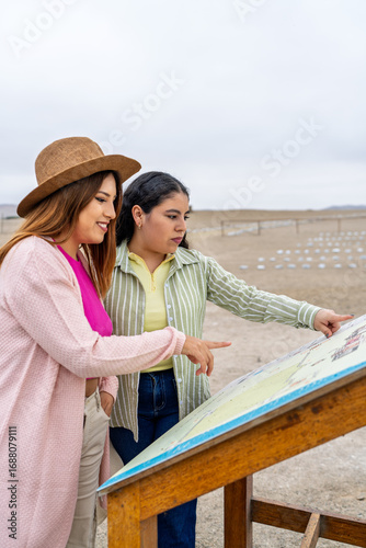 Tourists exploring pre inca ruins in desert using map