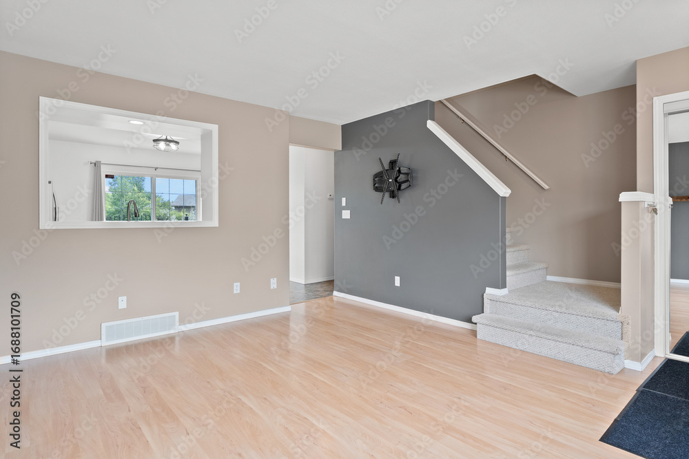 Fototapeta premium Large open living room with a grey wall and a staircase