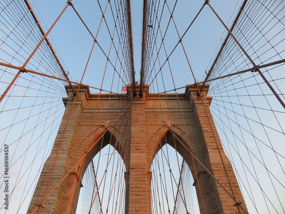 Fototapeta premium the view of a Brooklyn bridge arches, Manhattan, New York at dawn
