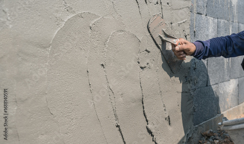 Bild auf Leinwand Hand worker man holding handle trowel equipment plaster cement wall background,