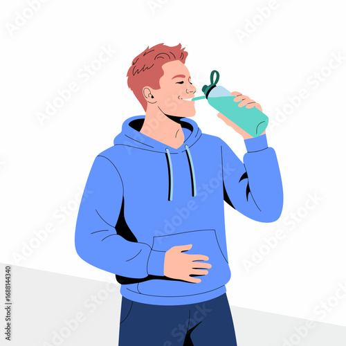 A young man in a blue hoodie drinks from a water bottle, evoking a sense of hydration and wellness while enjoying a refreshing break in a stylish manner.