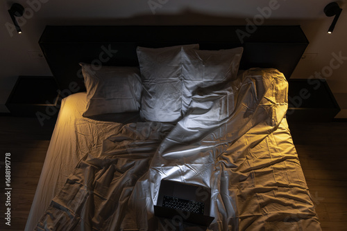 Tableau sur toile Overhead bed with laptop in warm and cool lighting. Night work.