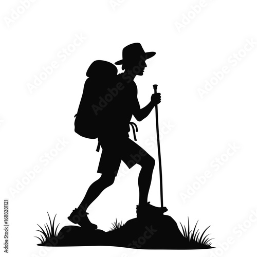 Silhouette of hiker with backpack and trekking pole on rocky ground