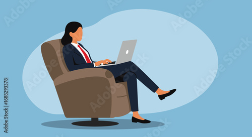 Professional woman in a business suit comfortably works on a laptop in an armchair. Ideal for concepts of remote work, productivity, or a flexible lifestyle.