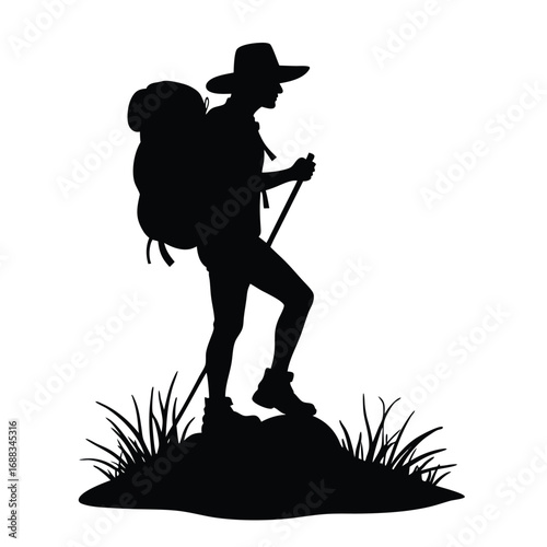 Silhouette of hiker with backpack and trekking pole on rocky ground