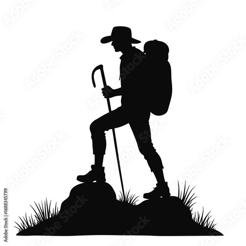 Silhouette of hiker with backpack and trekking pole on rocky terrain