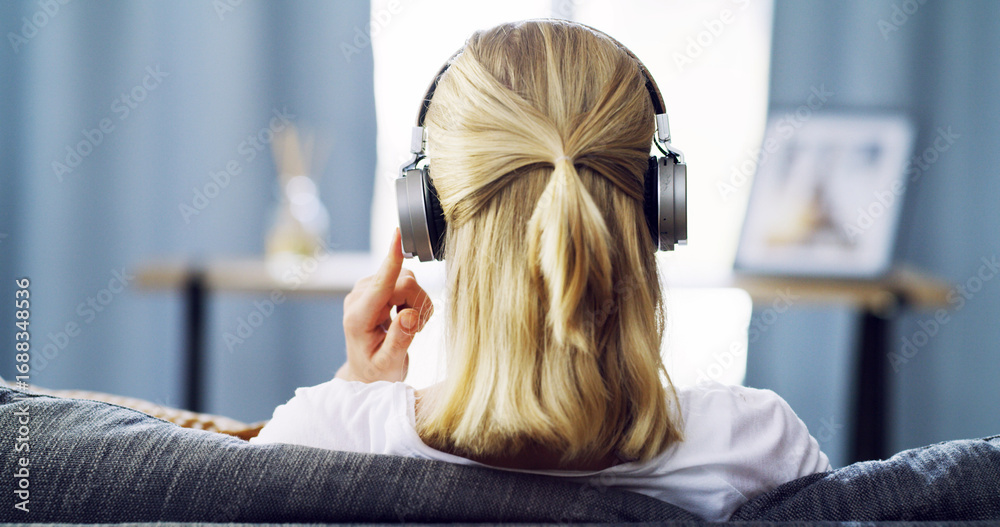 Fototapeta premium Back, headphones and peace with woman on sofa for streaming service, guided meditation and white noise. Zen radio, subscription and mindfulness with person in living room of home for wellness