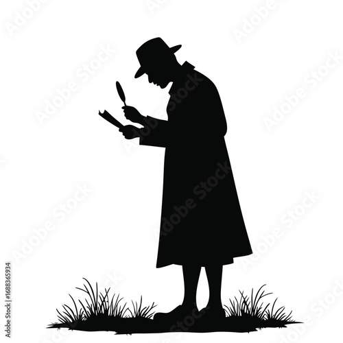 Silhouette of detective examining document in grass