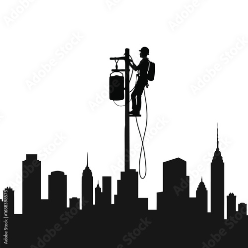 Lineman silhouette working on utility pole against city skyline