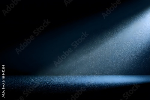 A dark blue beam of light shines against a black background, with nothing else in the frame. The texture of the material appears to be a soft, grainy film with a subtle gradient effect that gives an i