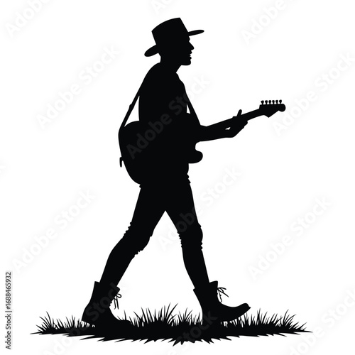 Silhouette of man with guitar walking through grass