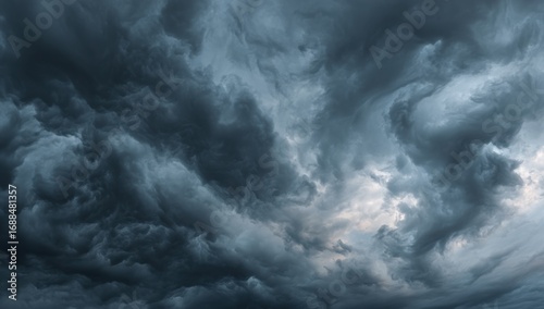 A dramatic close-up view of a stormy sky filled with dark, textured clouds