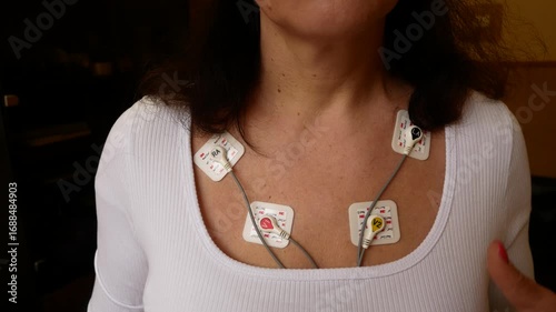 A woman with a holter device on her body to monitor cardiac activity. Portable ECG device records heart function during 24-hour everyday life. Diagnostics of heart function and detection of