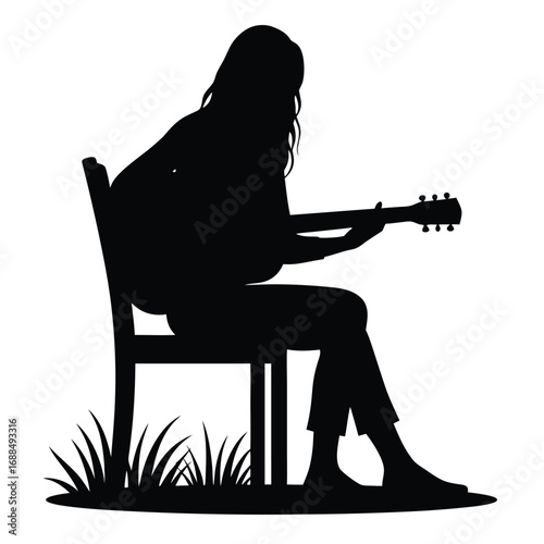 Silhouette of a person playing guitar while sitting on a chair outdoors