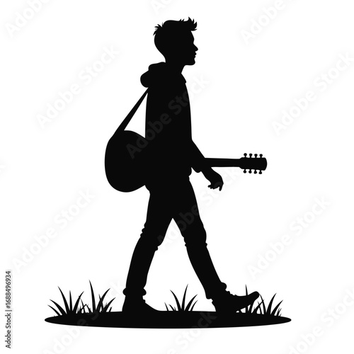 Silhouette of a young man walking with a guitar acoustic guitar