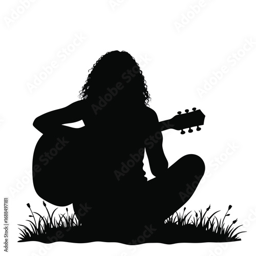Silhouette of person playing acoustic guitar in grass 1