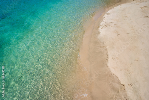 Aerial view of clear ocean water with sand beach for travel.