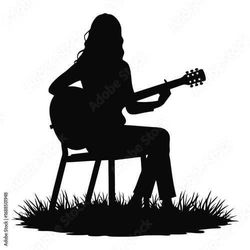Silhouette of woman playing acoustic guitar sitting on chair in grass 2